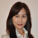 A woman with long hair and a white shirt.